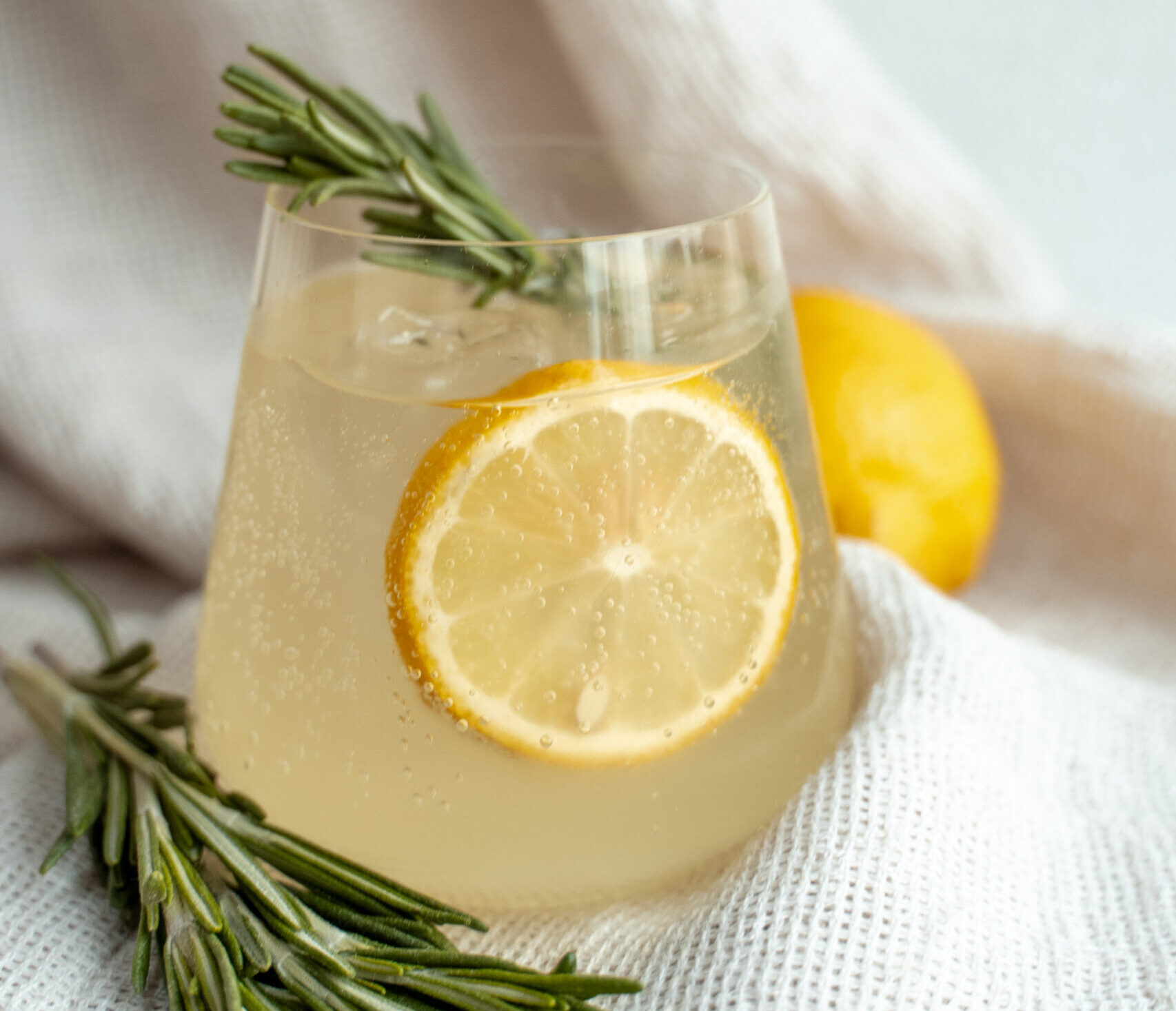 Bergamot spritz met een citroen en een takje rozemarijn