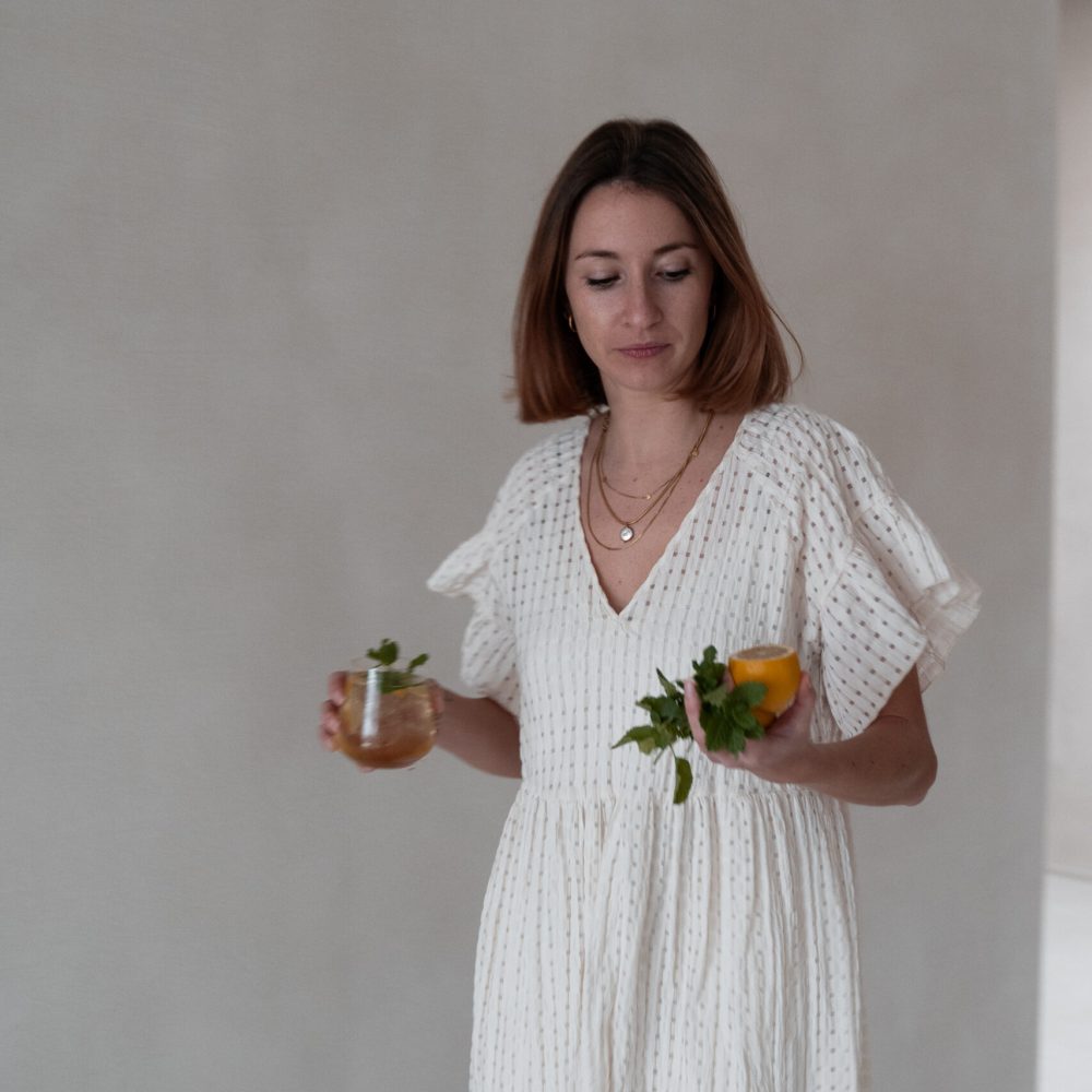 Caroline houdt een limoncello spritz en een bergamot spritz vast in een romantisch kleed