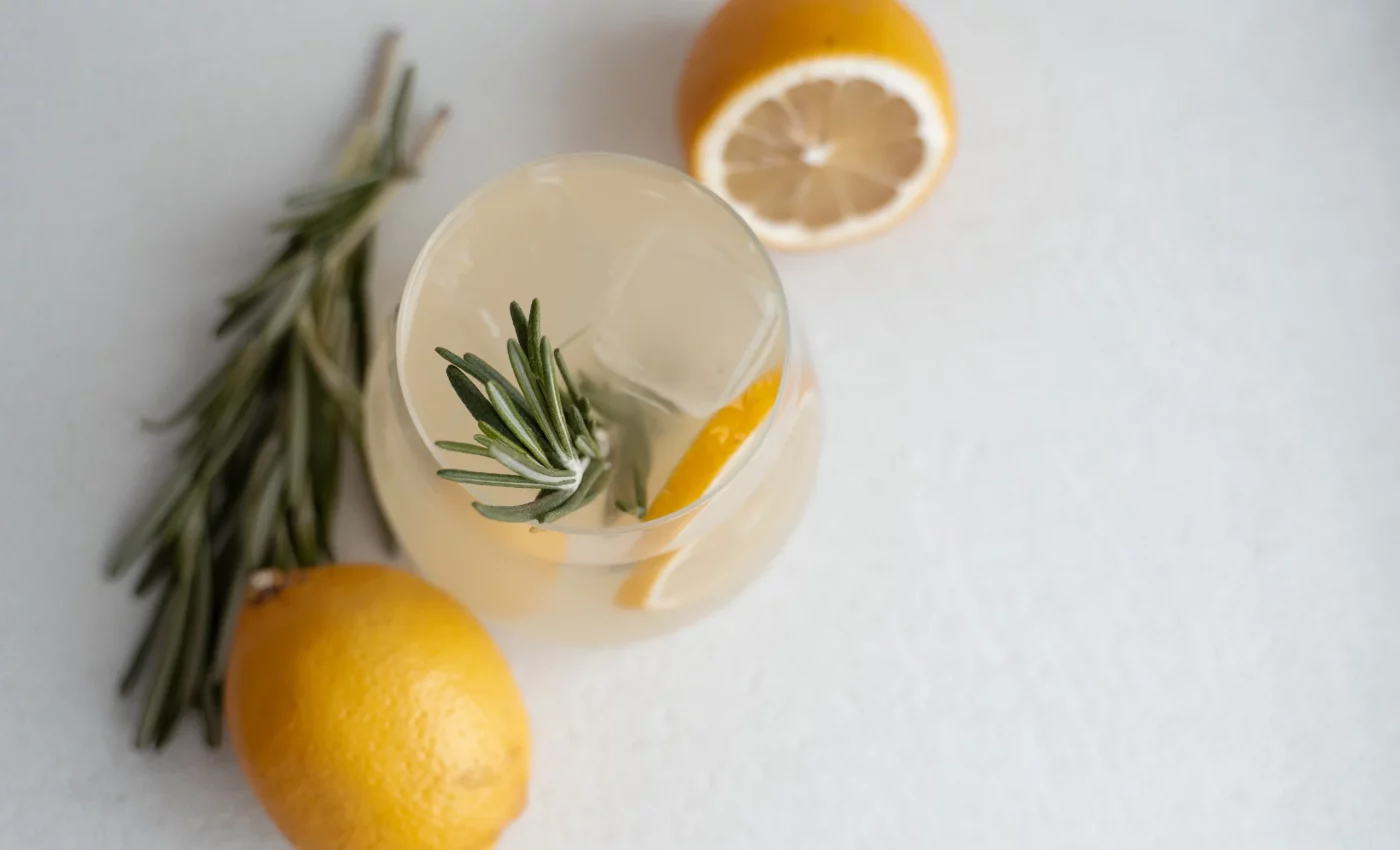 Een glas limoncello spritz met takjes rozemarijn. Verfrissend en aromatisch zomerdrankje.